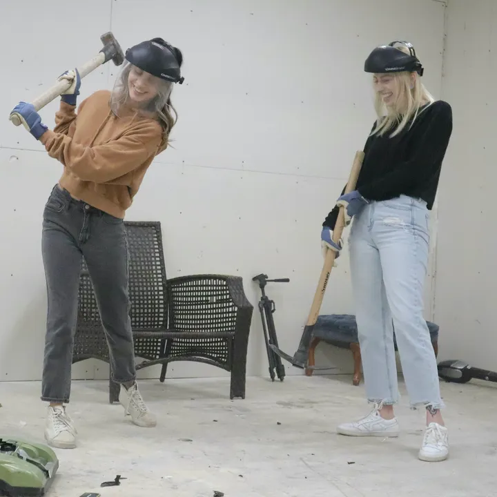 Two guests taking a swing in a private smash session