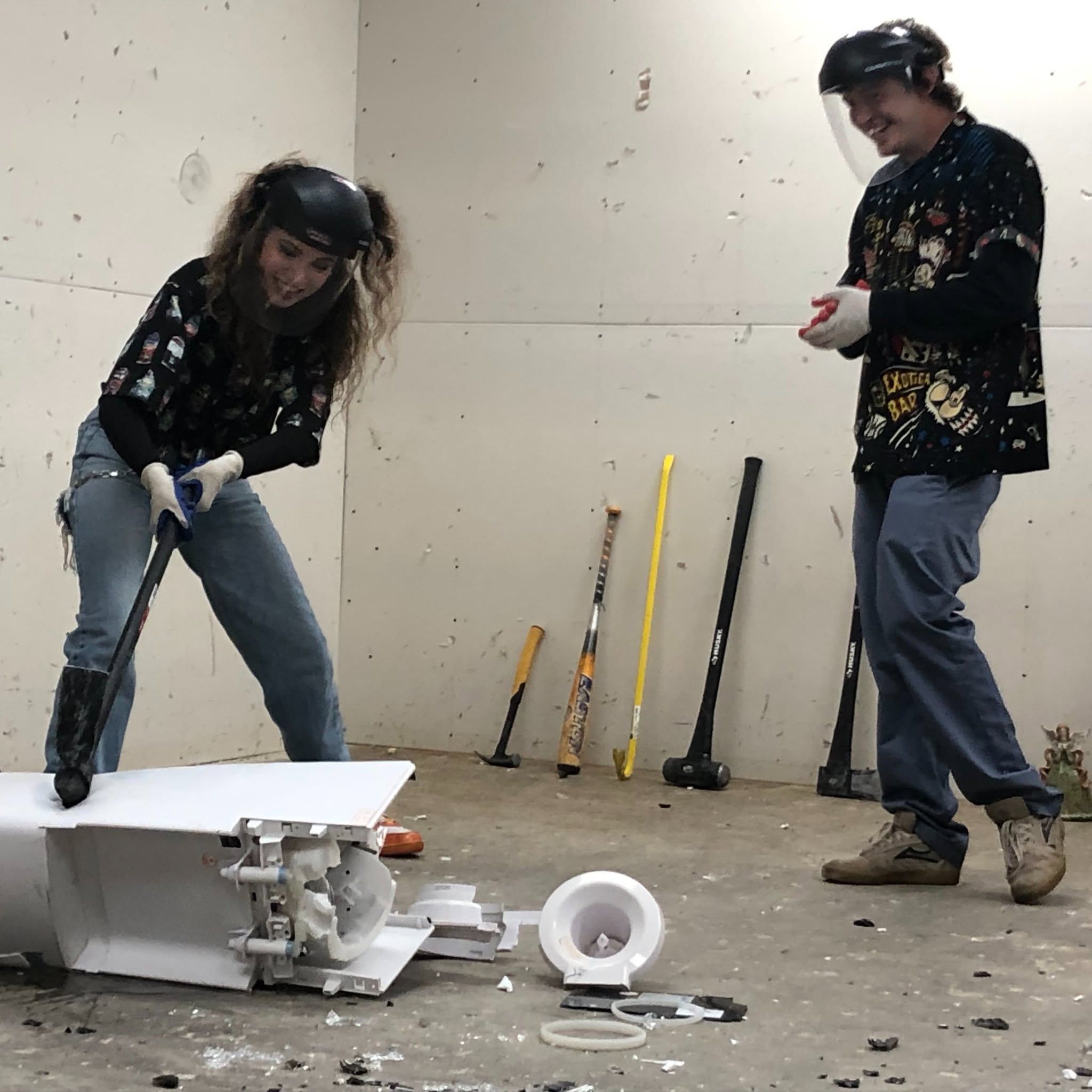 A guest swinging a sledgehammer to smash a toilet at The Smash Room Tulsa